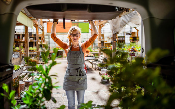 a female worker loading plants in the work van